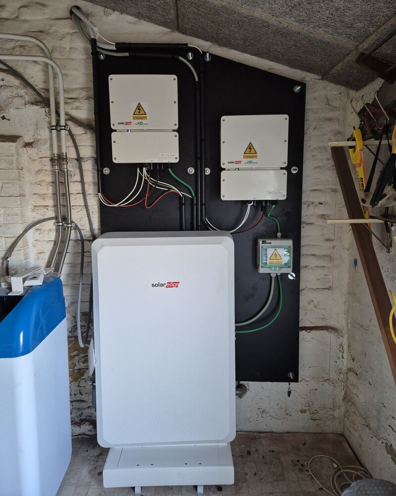 Batterie domestique et onduleurs SolarEdge installés au mur d’un garage.